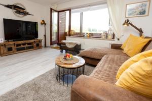 ein Wohnzimmer mit Sofa und Fernseher in der Unterkunft FeWo Harzer Leidenschaft bis 2 Hunde Willkommen TOP Lage DTV 5 Sterne 3 Pfoten in Sankt Andreasberg