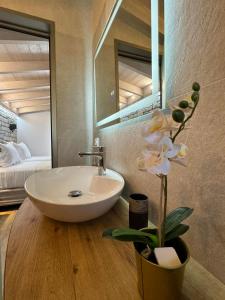 łazienka z umywalką i kwiatem w wazie w obiekcie Iris Villas Complex w mieście Leukada (miasto)