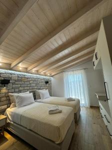 dwa łóżka w pokoju z ceglaną ścianą w obiekcie Iris Villas Complex w mieście Leukada (miasto)