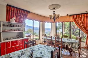 a dining room with a table and chairs and windows at Sunset Ridge Guest House in Rustenburg