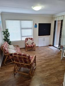 モッセル・ベイにあるCosy beach house in Diazのリビングルーム(椅子、薄型テレビ付)
