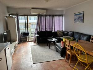 Una sala de estar con un sofá negro y una mesa. en Luke's Alpine Mountain View rooms, en Jindabyne