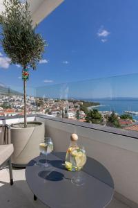 a table with two wine glasses on top of a balcony at Exlusive Villa M -Baska Voda in Baška Voda