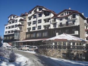 a large building with cars parked in front of it at Snezhanka Apartments TMF in Pamporovo