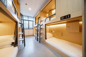 a room with three bunk beds in a hostel at Denpa Inn - The Bund East Nanjing Road in Shanghai