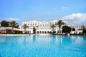 una gran piscina frente a un gran edificio blanco en TMK L'Atrium Yasmine by Turismark, en Hammamet