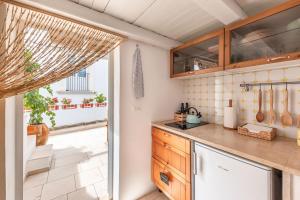 a kitchen with wooden cabinets and a large window at Elena's house 28 in Polignano a Mare