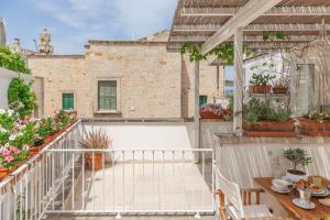 a balcony with potted plants and a table at Elena's house 28 in Polignano a Mare