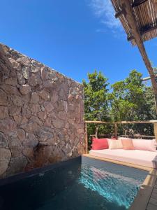 a room with a bed and a stone wall at Les Petites Maisons in Sotta