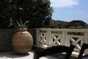 a large vase sitting next to a white fence at Aithra -Agios Petros Andros in Gavrio
