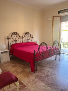a bedroom with a bed with a red bedspread at Casa Giovenza in Porto Azzurro