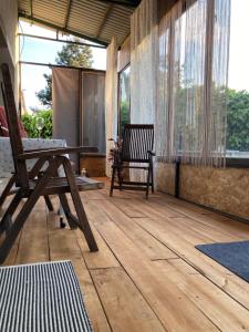 a screened in porch with a bench and a table at Bodrog-Parti Lodge in Sárospatak +14 photos
