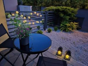 a patio with a table and flowers and a fence at Willa Racławicka Apartments in Poznań