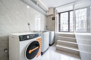 a washer and dryer in a room with a window at Denpa Inn - The Bund East Nanjing Road in Shanghai