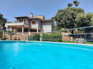 a large blue swimming pool in front of a house at Villa Capllonch in Banyalbufar