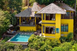 an aerial view of a yellow house with a swimming pool at SAii Phi Phi Island Village in Phi Phi Islands