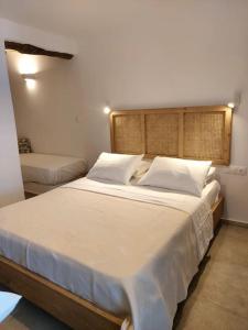 a bedroom with a large bed with white sheets and pillows at Krodoma house 1 in Ios Chora