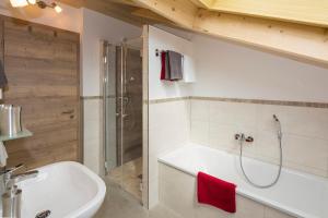 a bathroom with a shower and a sink and a tub at Ferienwohnung Bergspitz in Grainau +20 photos