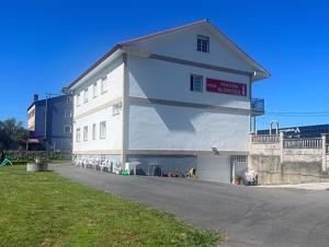 a large white building on the side of a street at Pensión Glorioso II in Picaraña