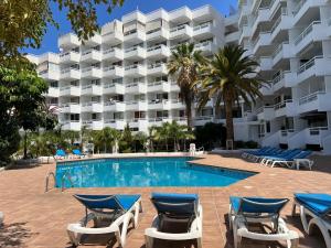 a resort swimming pool with lounge chairs and a hotel at Tenerife Sea View Sun Beach Apartment 214 in Playa Fañabe