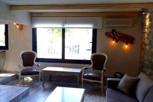 a room with chairs and a table and a window at Green and Blue View in Elliniká
