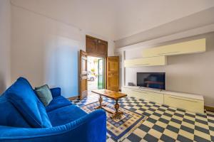 a living room with a blue couch and a table at Starhost - ANGOLO FELICE, charming seaview terrace in Vietri sul Mare