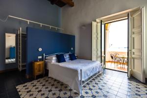 a bedroom with a bed with a blue wall at Starhost - ANGOLO FELICE, charming seaview terrace in Vietri sul Mare