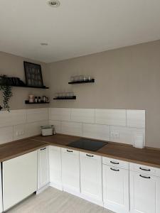 una cucina con armadietti bianchi e ripiani in legno di Ferienwohnung MONI a Penkun
