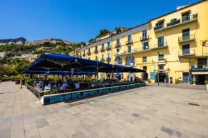 a seating area with a blue umbrella and a building at Starhost - ANGOLO FELICE, charming seaview terrace in Vietri sul Mare