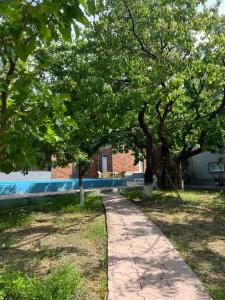 a path in a park with trees and a building at Jrvezh House in Yerevan