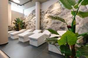 a row of white benches in a room with plants at Paros Agnanti Resort & Spa in Parikia