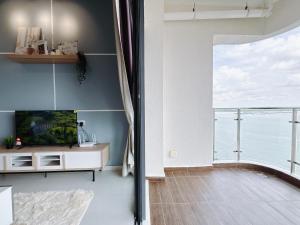 a living room with a tv and a large window at Scenic Country Garden Danga Bay by Lions Bay in Johor Bahru +15 photos