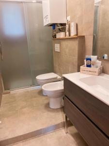 a bathroom with a toilet and two sinks and a shower at Appartamento con piscina a 100metri dal mare in Castiglioncello +9 photos