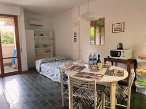 a room with a bed and a table with chairs at Casa Caletta - Appartamento con piscina a 100metri dal mare in Castiglioncello