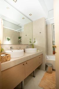 two sinks in a bathroom with a large mirror at Maria's Airport Apartment, 4' metro, 10' airport, 15' beach, 40' city center in Koropíon