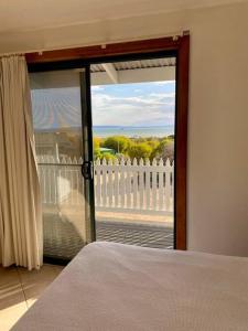 Nectar BrookSpear Creek Beach House的卧室设有滑动玻璃门,可通往阳台