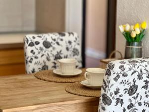 サンミゲル・デ・アボナにあるPenthouse in Golf del Sur 2の2つのカップと椅子と花が置かれた木製のテーブル +25枚の写真