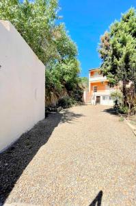 a driveway in front of a house with trees at Residenza Centrale in Villasimius