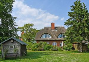 ein großes Backsteinhaus mit Dach in der Unterkunft Landhaus am Deich in Middelhagen