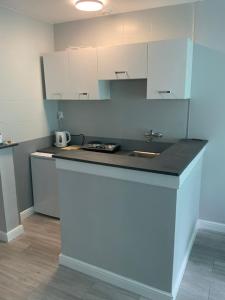 a kitchen with white cabinets and a counter top at Apartamencik Konopnickiej 2 in Dziwnów