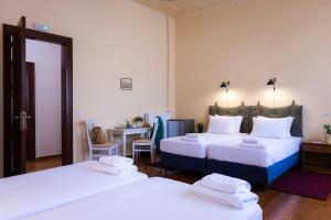 a room with two beds and a table with a desk at Sundial Lodge in Chania