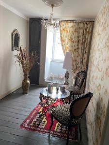 a room with a table and chairs and a window at la romantique in Sainte-Marie-aux-Mines