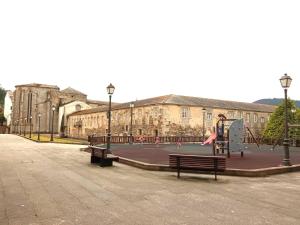 a person playing on a playground in front of a building at OLI VITA HOLIDAY HOME 4 O 2 PEOPLE Viveiro VUT-LU-3838 in Viveiro