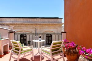 a patio with two chairs and a table with a bottle of wine at Casa Acropoli Sea View Taormina Center in Taormina