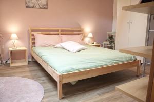 a bedroom with a large bed with green sheets and pink pillows at La mansardina in Trieste