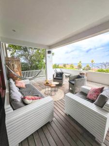 a patio with couches and a hammock on a deck at Luxe zeezicht appartement Bayside, Jan Thiel Boca Gentil in Willemstad