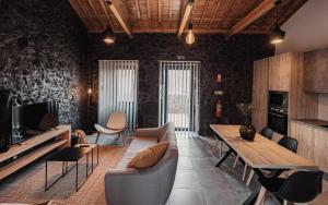 a living room with a wooden table and chairs at Casa de Campo Rocio do Mar in Santa Cruz da Graciosa