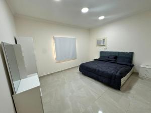 a bedroom with a bed in a white room at نجوم السعد 6 in Al Masfalah