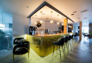 eine Bar mit schwarzen Barhockern in einem Restaurant in der Unterkunft Hotel Saline in Inowrocław