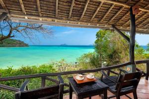a table with two chairs and a view of the ocean at SAii Phi Phi Island Village in Phi Phi Islands